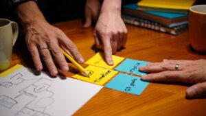 manos de trabajo sobre mesa con notas adhesivas y bocetos manos de trabajo sobre mesa con notas adhesivas y bocetos